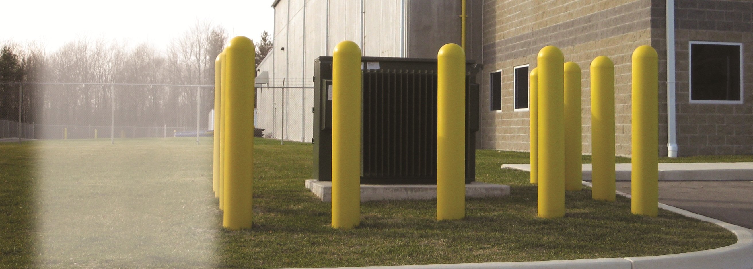 Yellow Precast Concrete Safety Bollards Surrounding Hydro Box